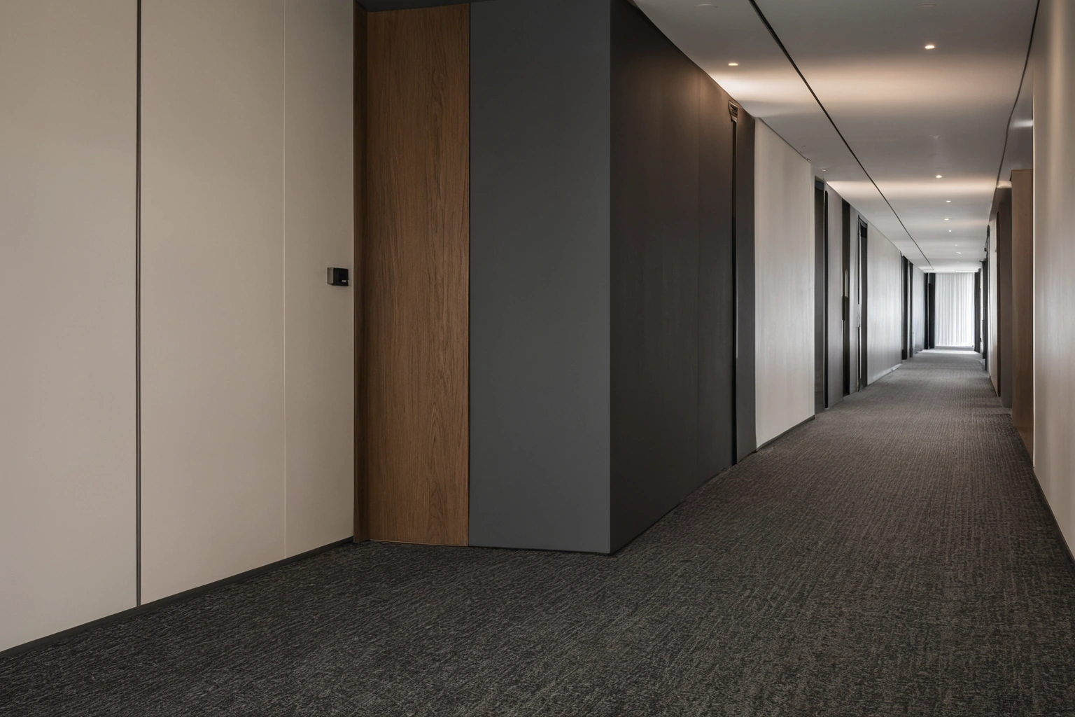 Broadloom contract carpet running the length of a hotel corridor, with a border strip along both walls